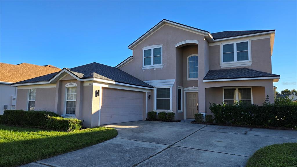 a front view of a house with a yard and garage