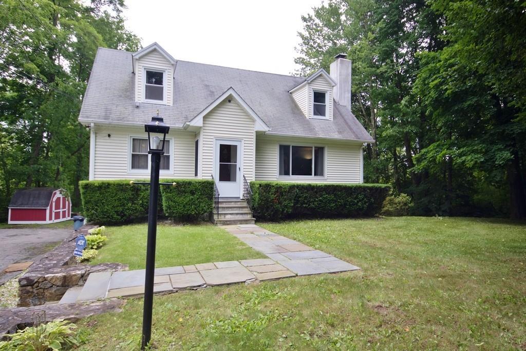 Cape cod house featuring a shed and a front yard