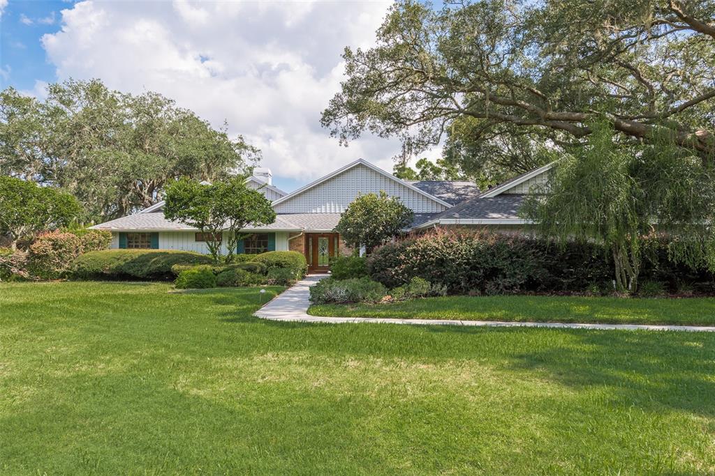 a front view of a house with a yard and trees