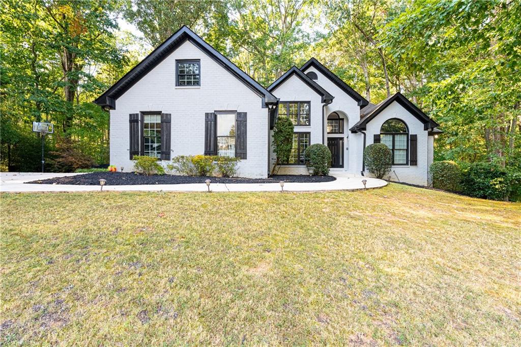 a front view of a house with a yard and trees