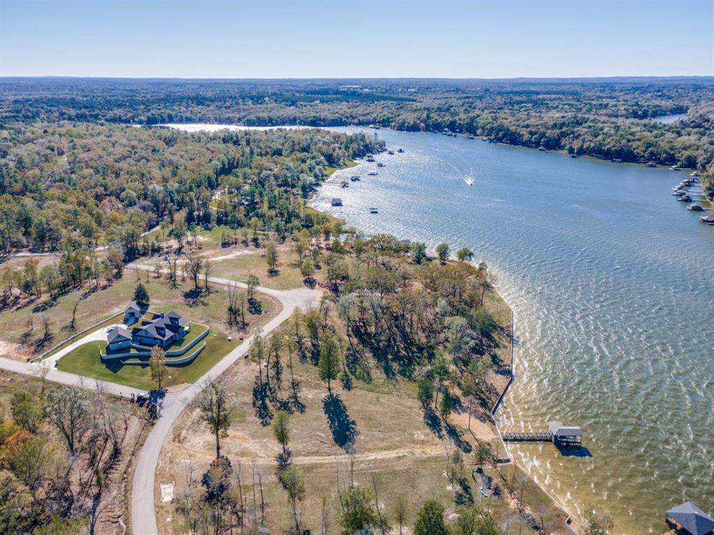 an aerial view of a house with a yard and lake view