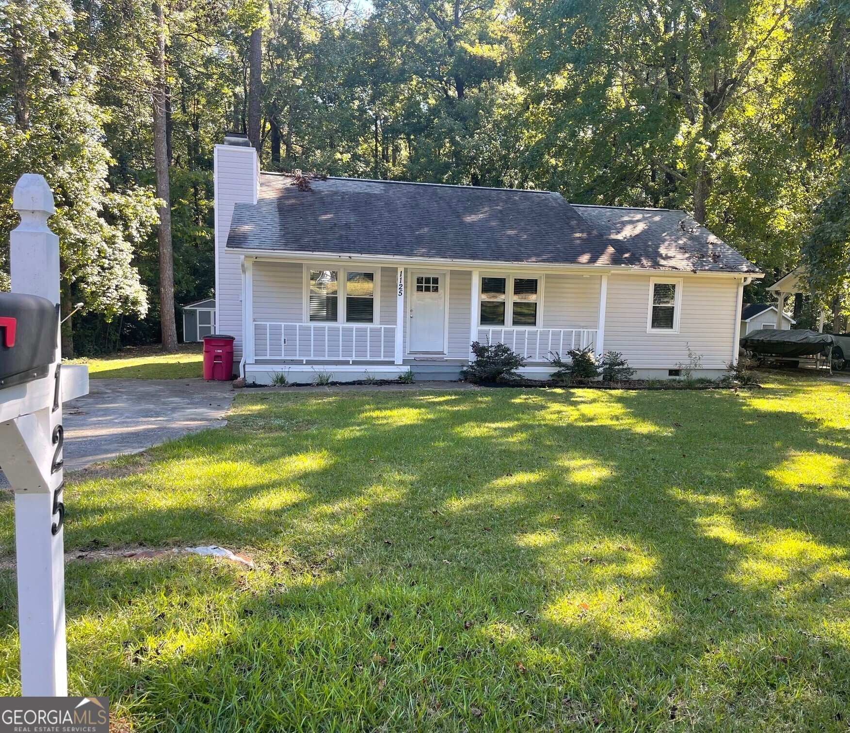 a view of a house with a big yard and large tree and a big yard