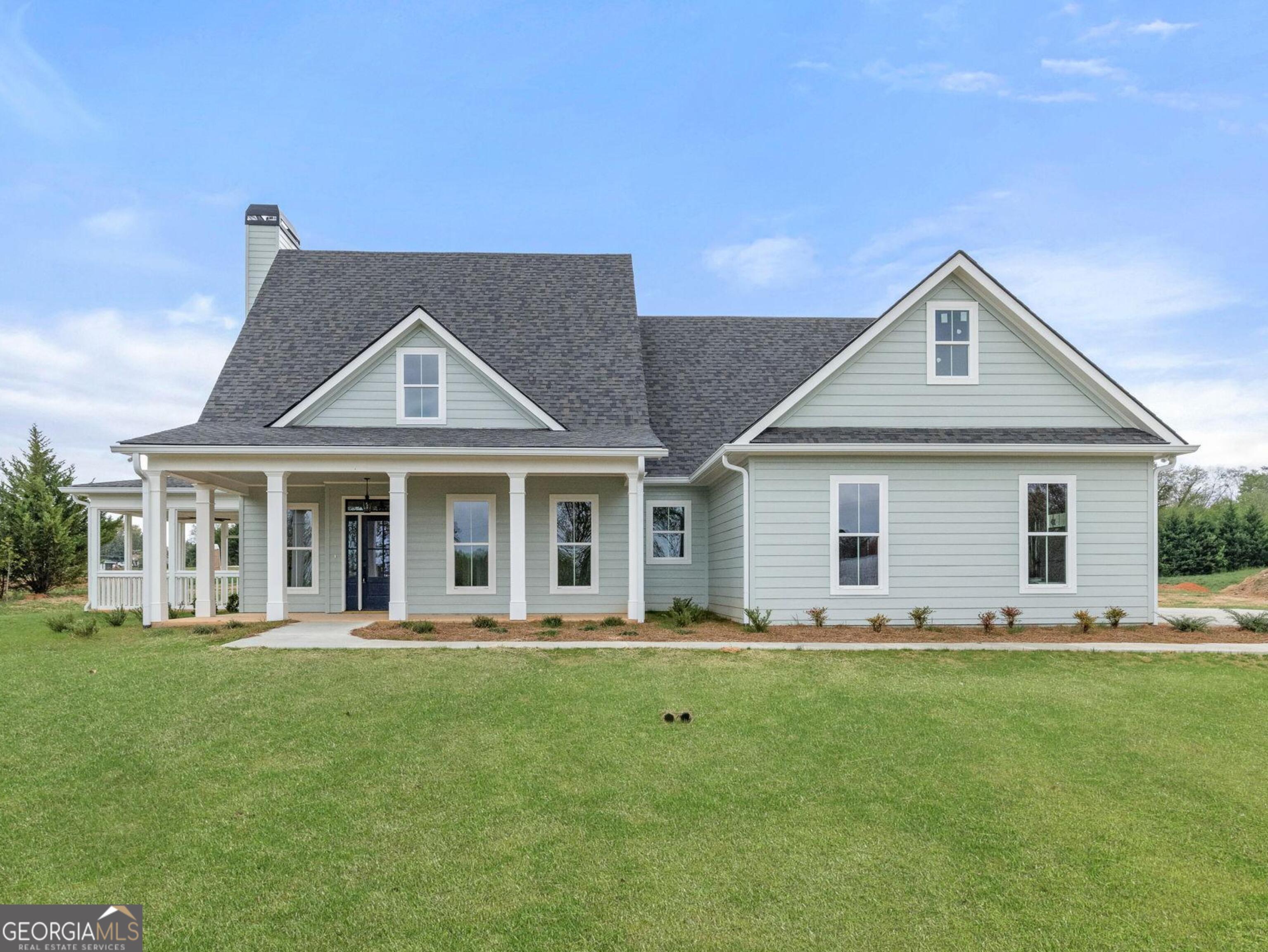 a front view of a house with a yard and trees