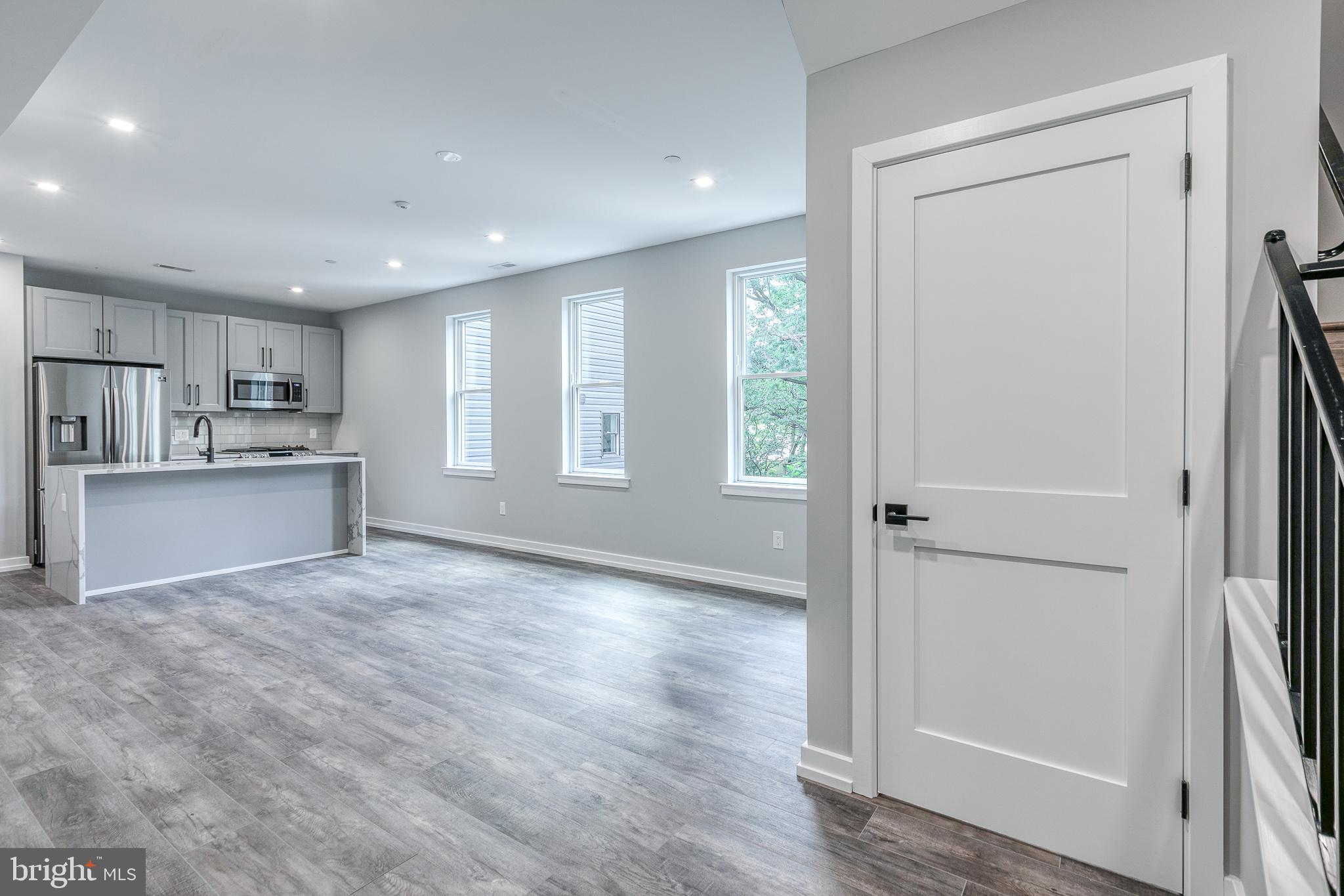 a view of a kitchen with wooden floor and a sink