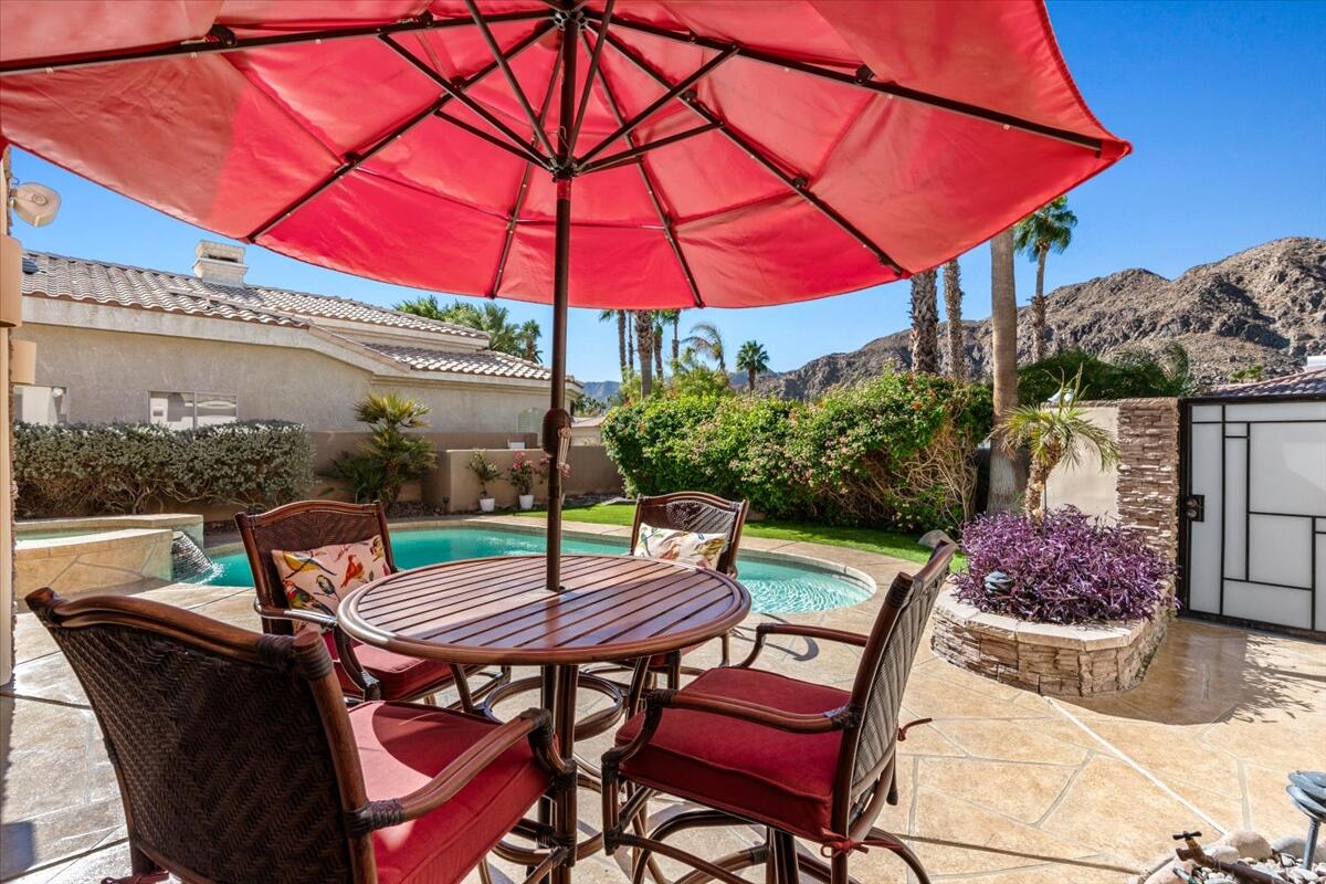 a patio with a table and chairs under an umbrella