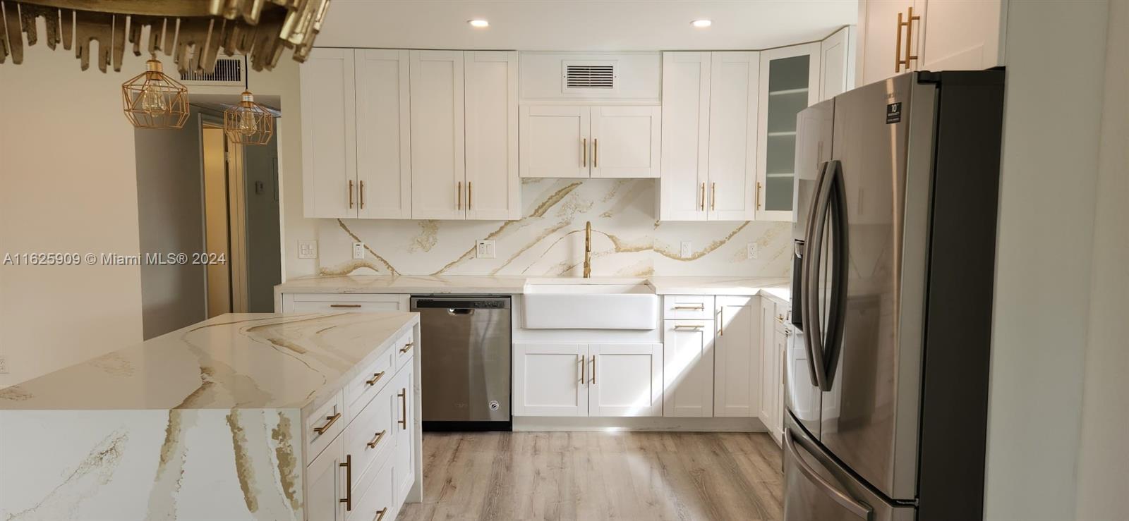 a kitchen with stainless steel appliances kitchen island a refrigerator sink and cabinets