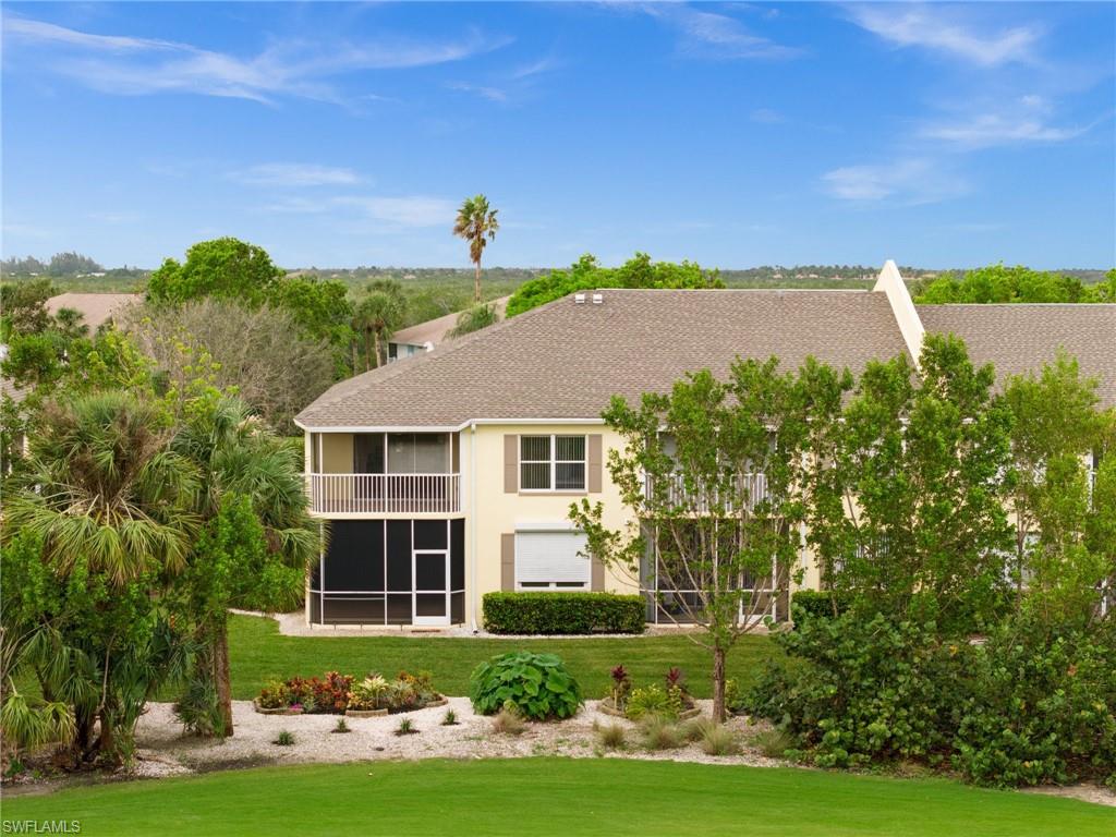 Back of house with a lawn and a sunroom