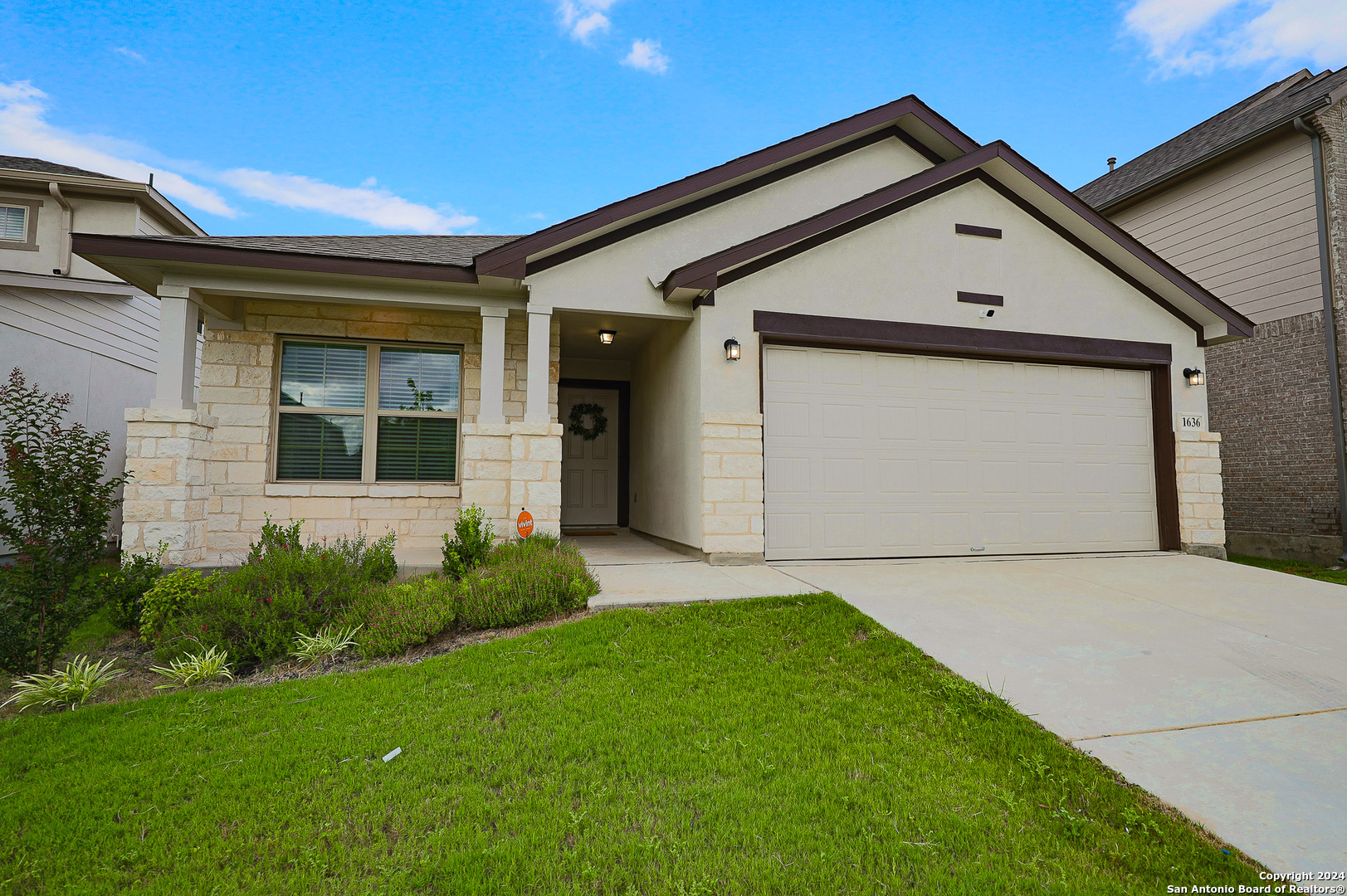 a front view of a house with garage and yard