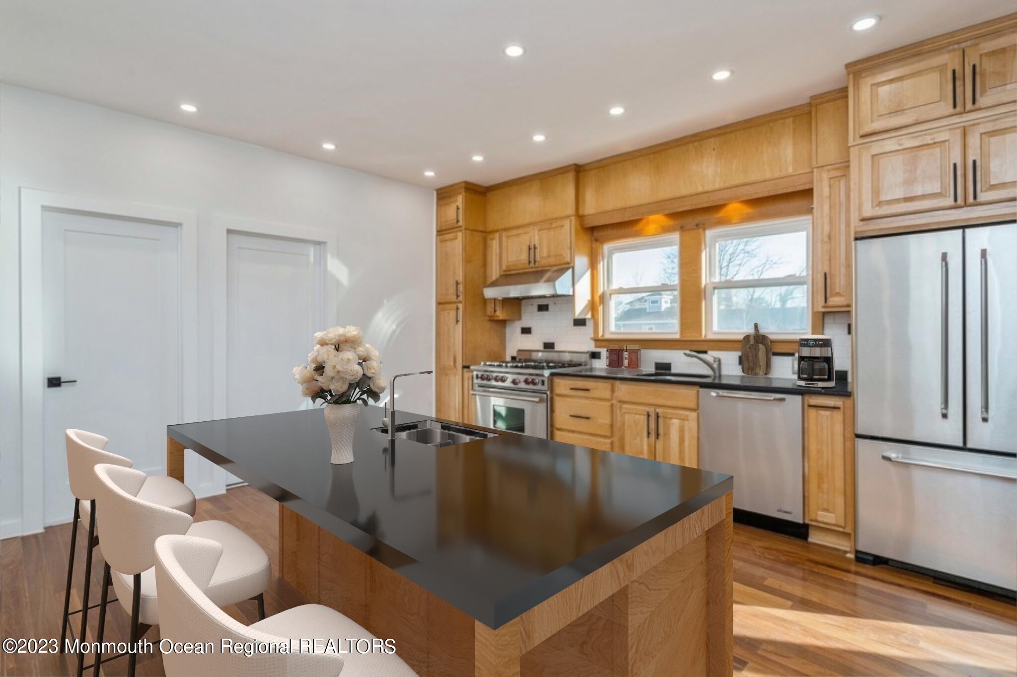 a kitchen with stainless steel appliances granite countertop a table chairs and a refrigerator