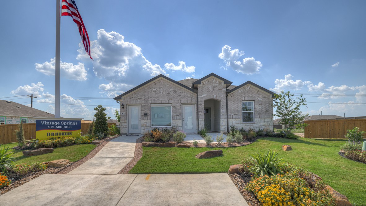 a front view of a house with yard and green space