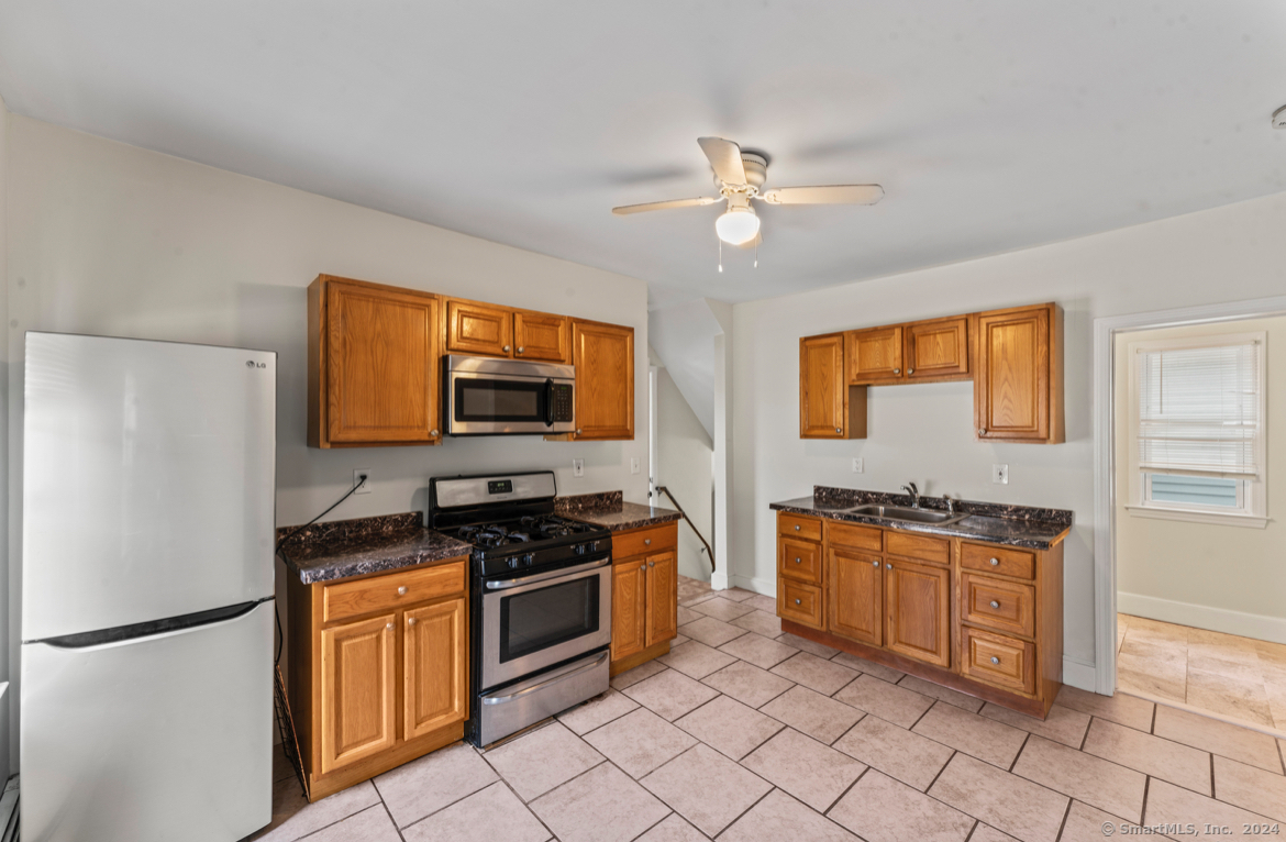 a kitchen with stainless steel appliances granite countertop a stove a refrigerator and a sink