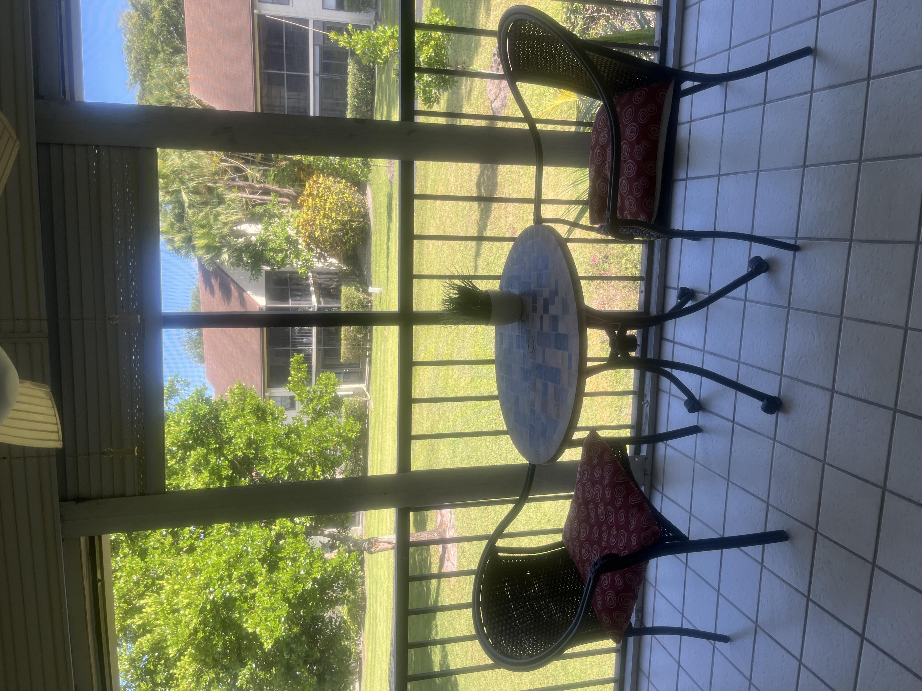 a view of a chairs and table in patio next to a yard