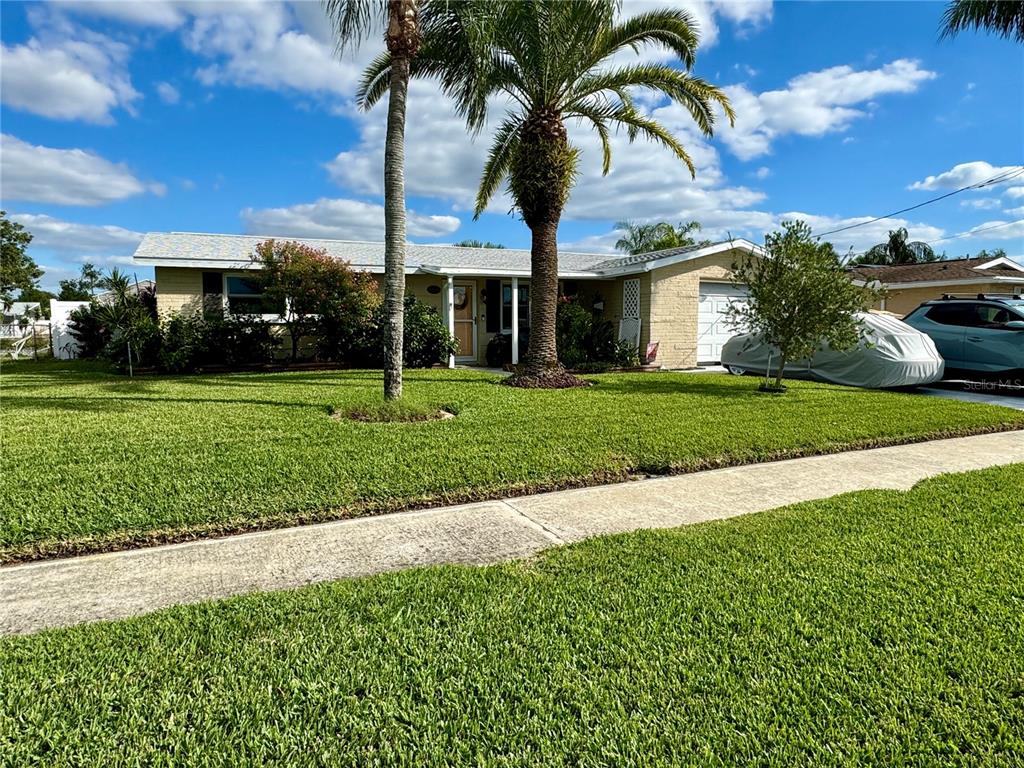 a front view of a house with a garden and yard