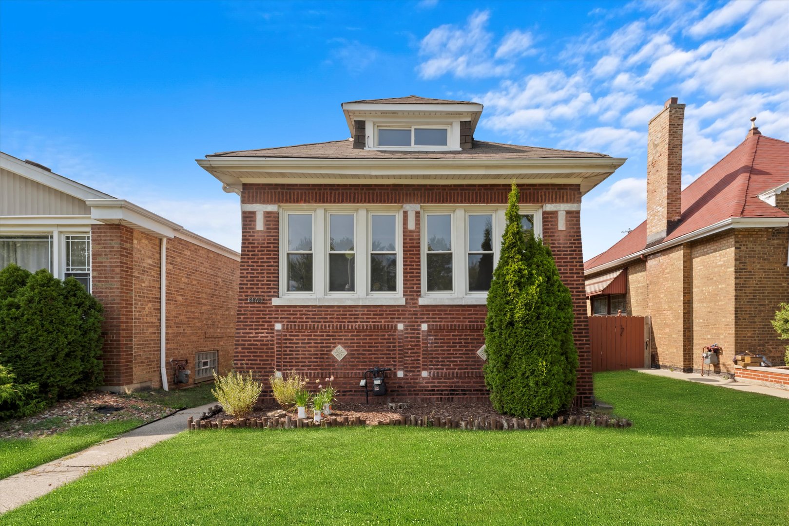 a front view of a house with a garden and yard