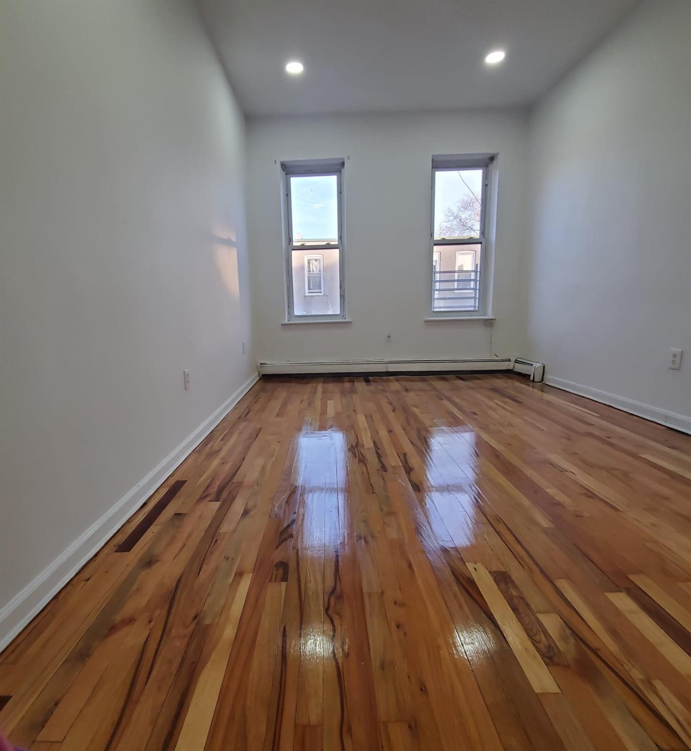 Spare room featuring hardwood / wood-style flooring and a baseboard heating unit