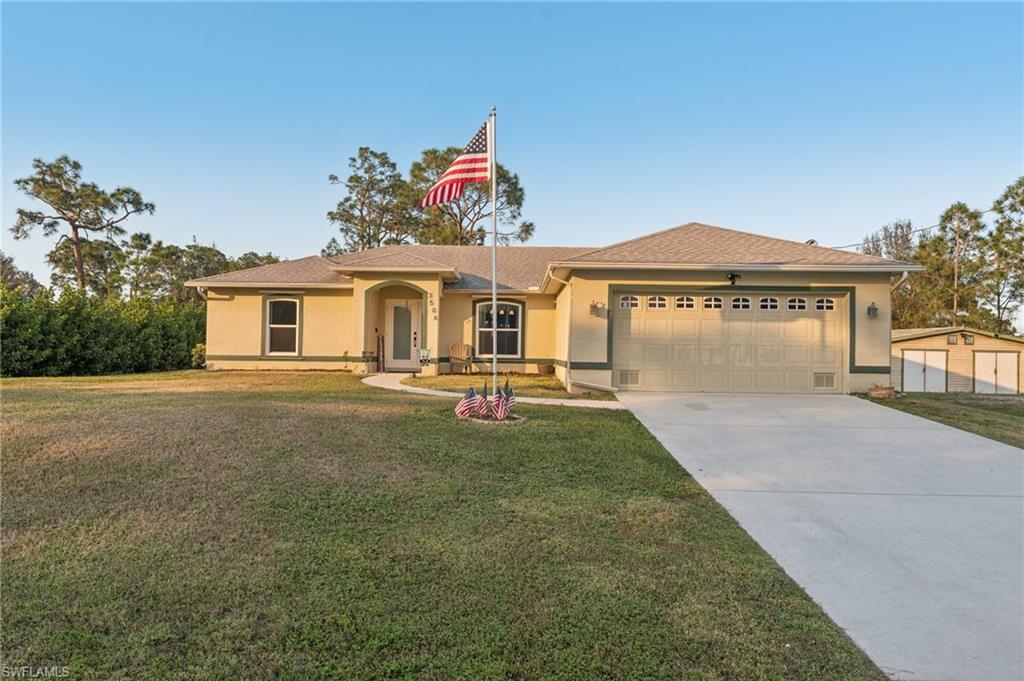 Ranch-style home featuring a front yard and a garage