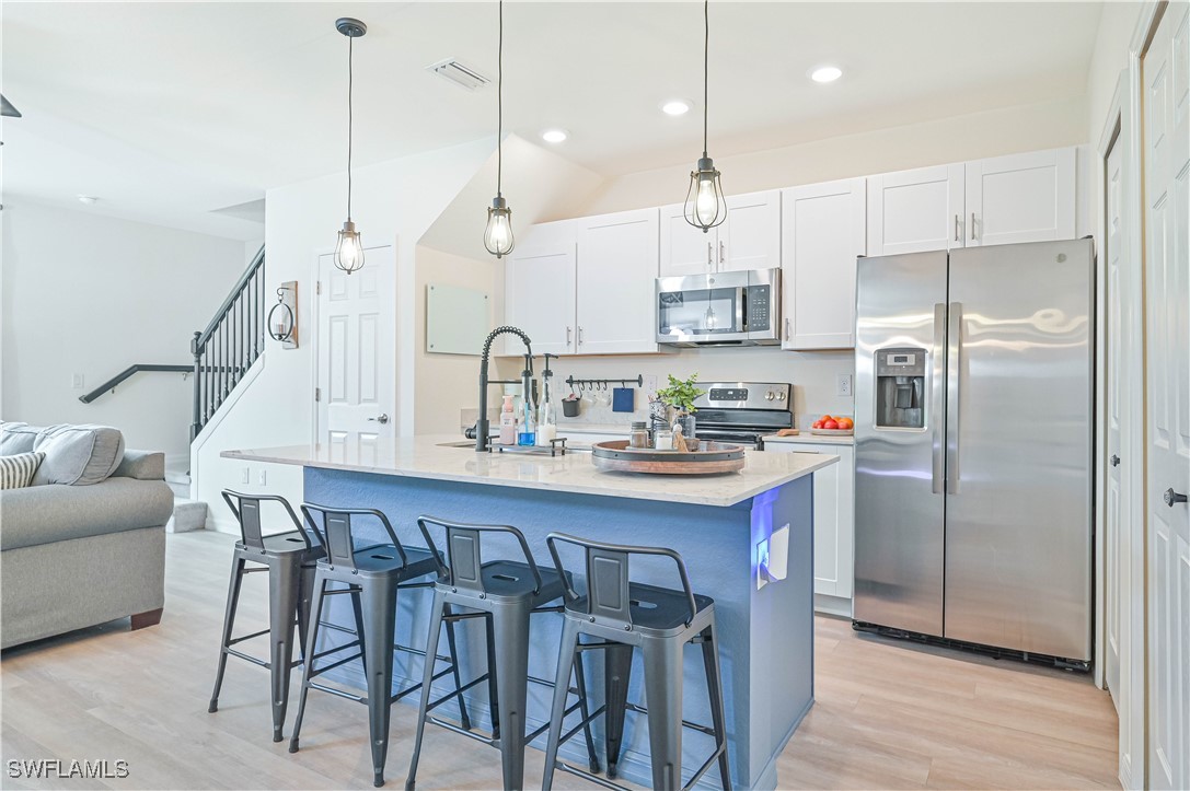 a kitchen with kitchen island a wooden floor and white appliances