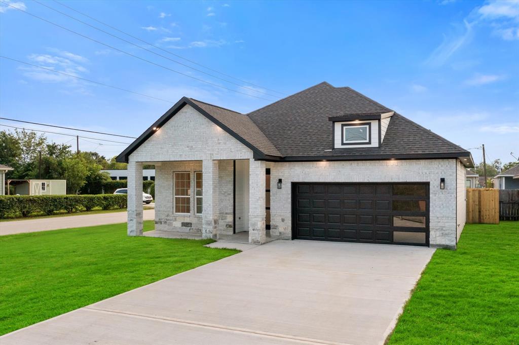 This modern gem sits on an oversized corner lot! The exterior elevation features a stunning combination of stone and brick, complemented by a refined black & white color palette and soffit lights that add a touch of sophistication.