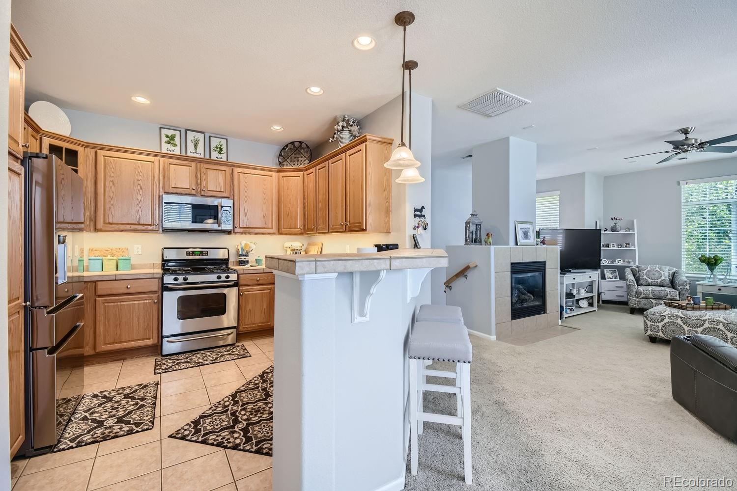 a kitchen with stainless steel appliances kitchen island granite countertop a stove top oven a sink dishwasher a dining table and chairs with wooden floor