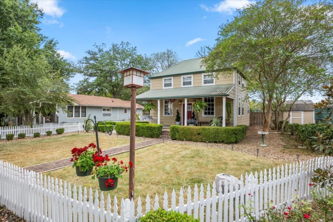 a front view of a house with a porch and a garden