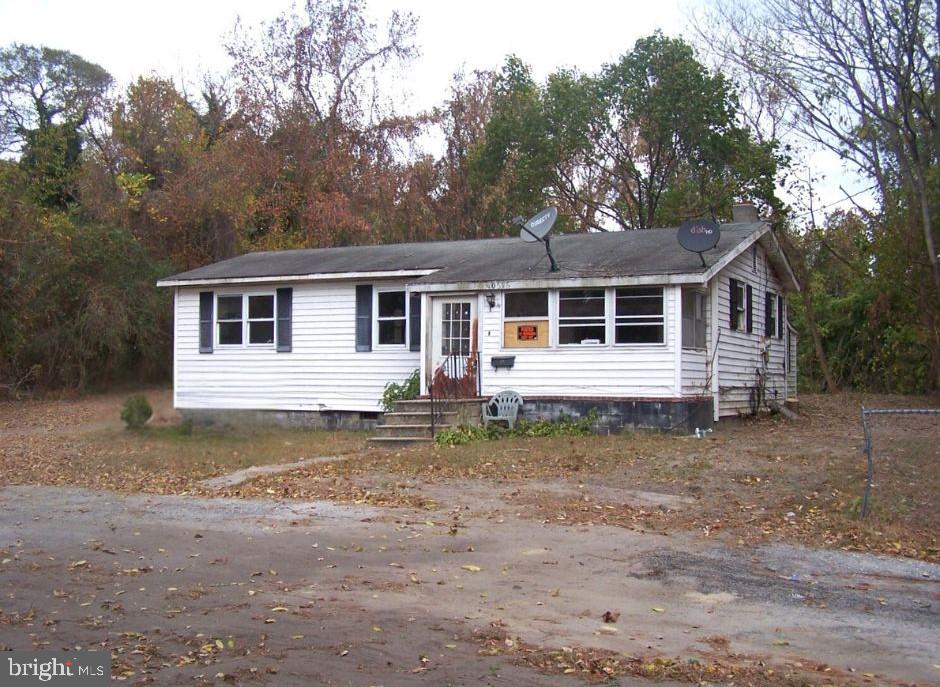 a view of a yard in front of a house with large trees