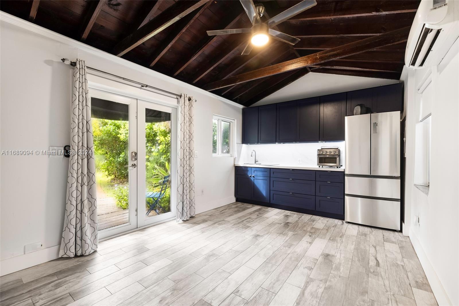 a kitchen with a refrigerator and a wooden floor