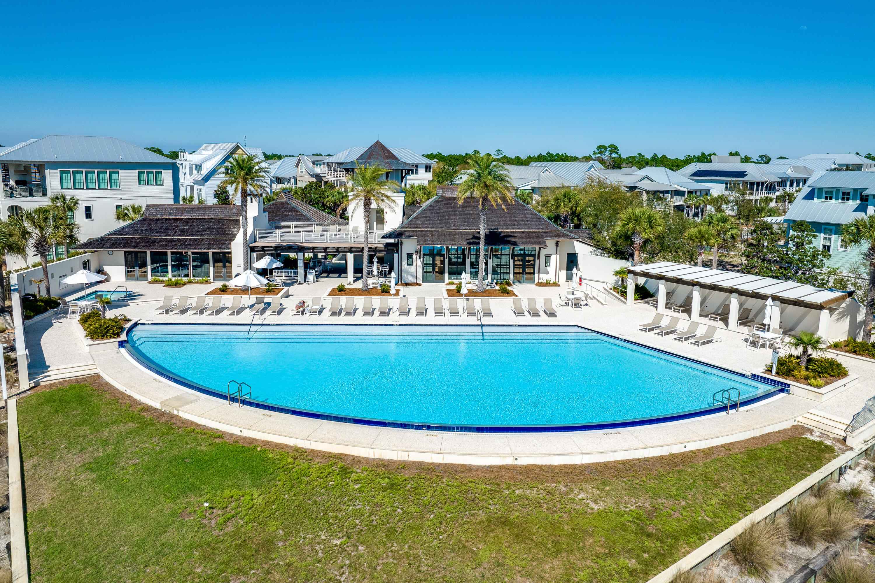 a view of a swimming pool with a lawn chairs under an umbrella