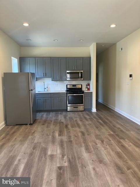 a room with kitchen island a sink and a stove top oven