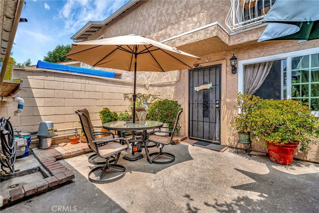 a view of a backyard with table and chairs under an umbrella