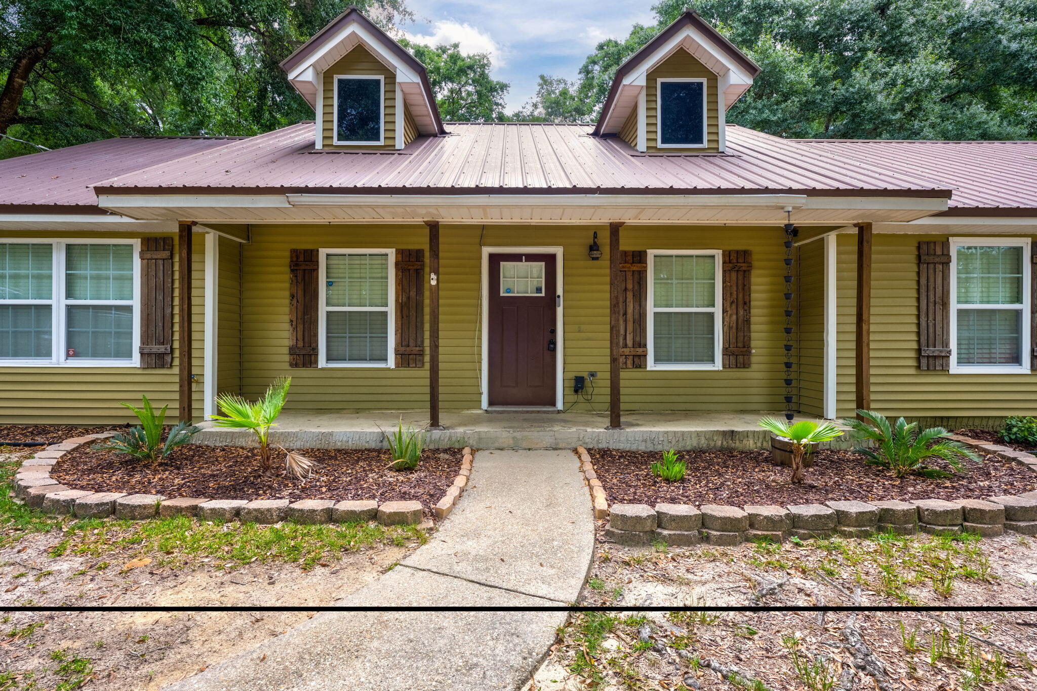 a front view of a house with garden