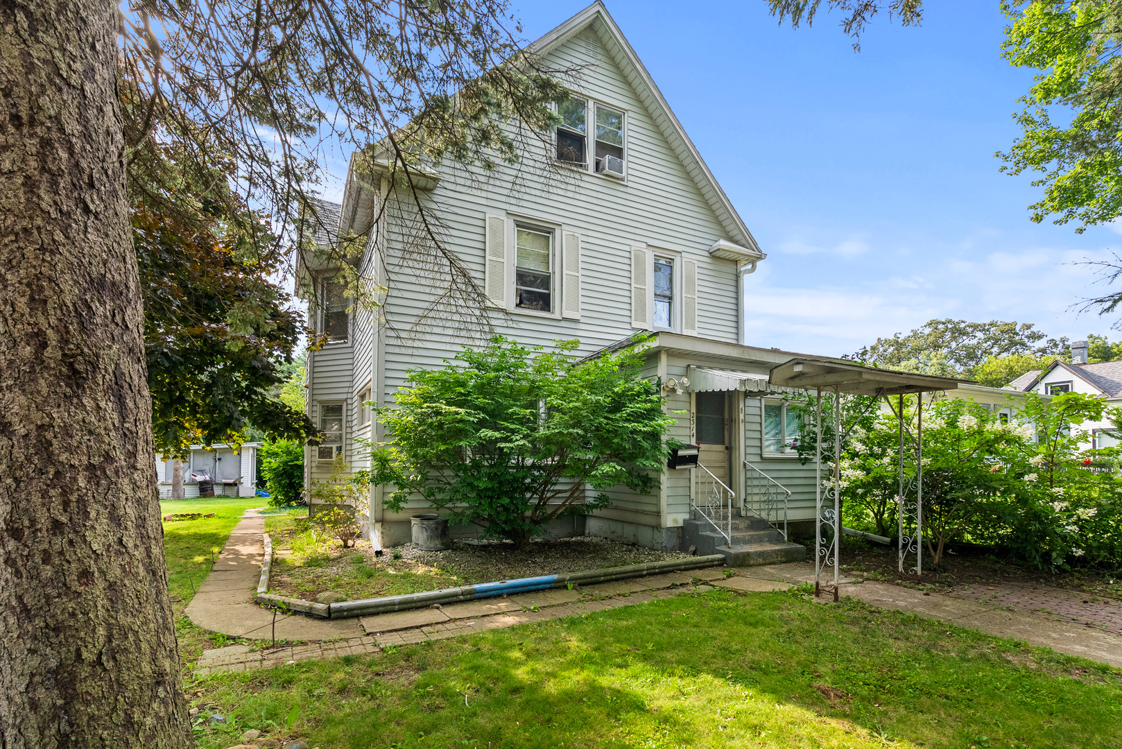 a view of a house with backyard and sitting area