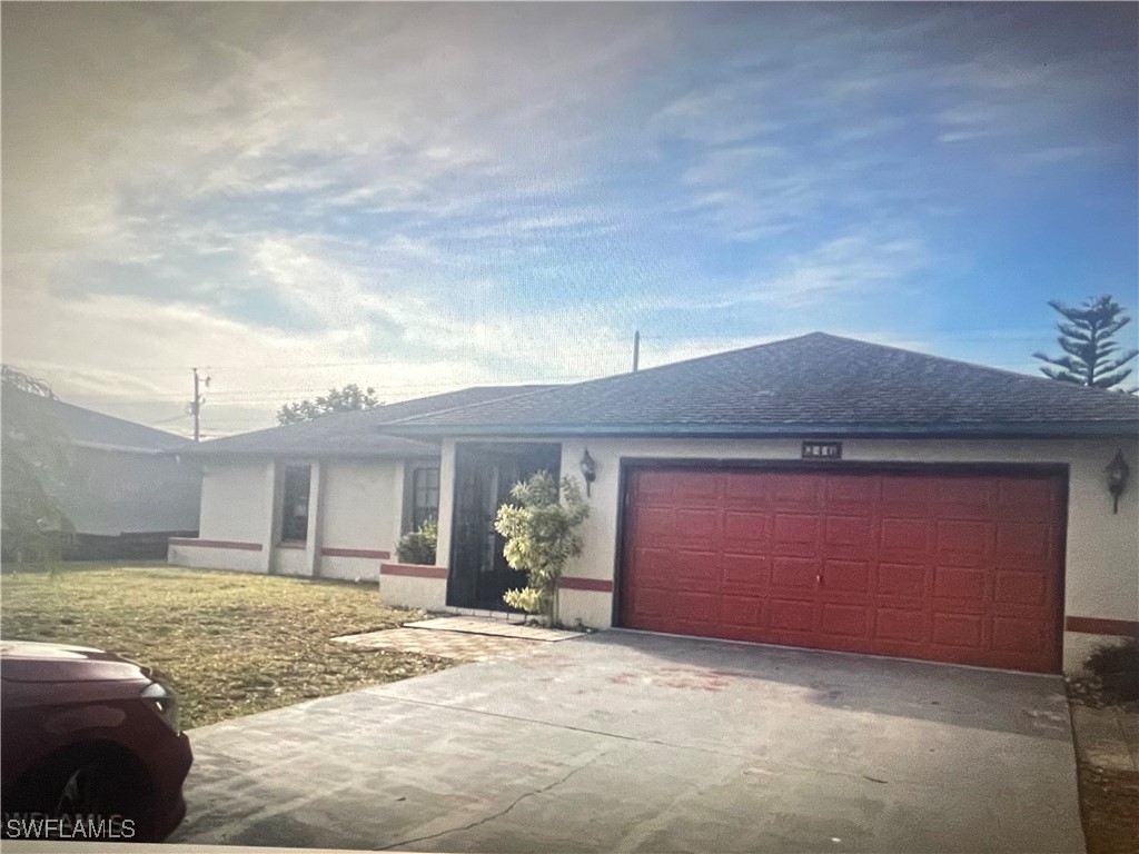 a view of a house with backyard and garage