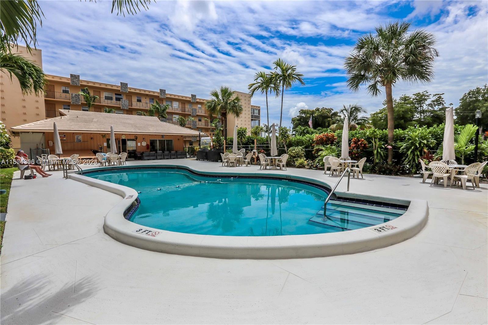 a view of a swimming pool with a patio and plants