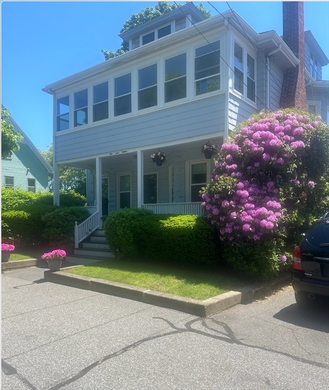 a view of a house with a yard and a bench