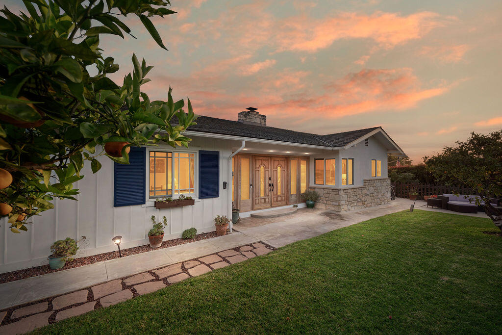 a front view of a house with a garden and patio