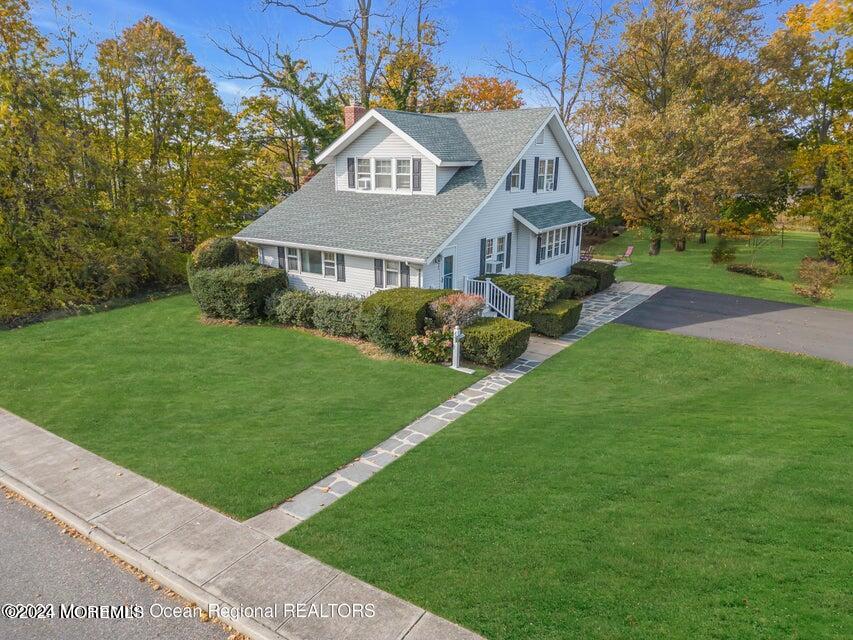 a view of a big house with a big yard and large trees