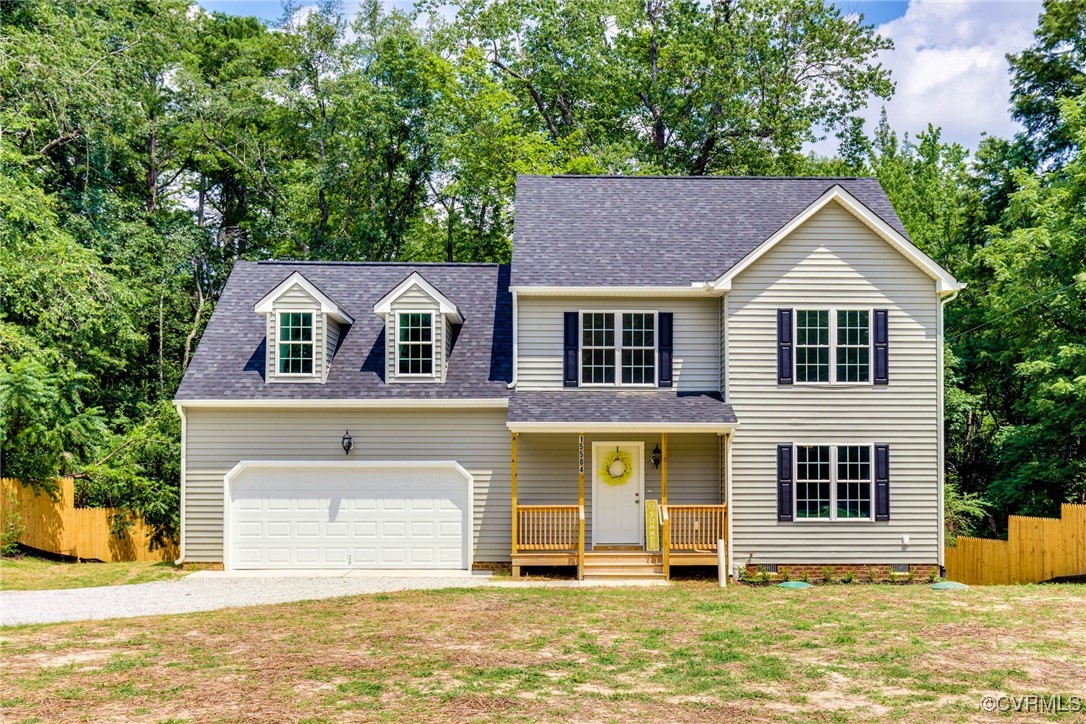 View of front of home with a front yard and a gara