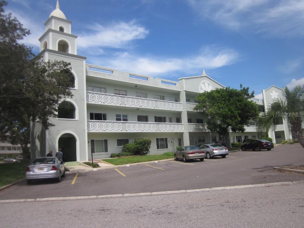 a front view of a building with cars parked