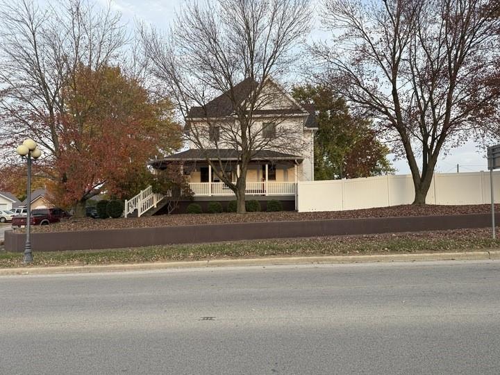 a view of a house with a yard and large trees