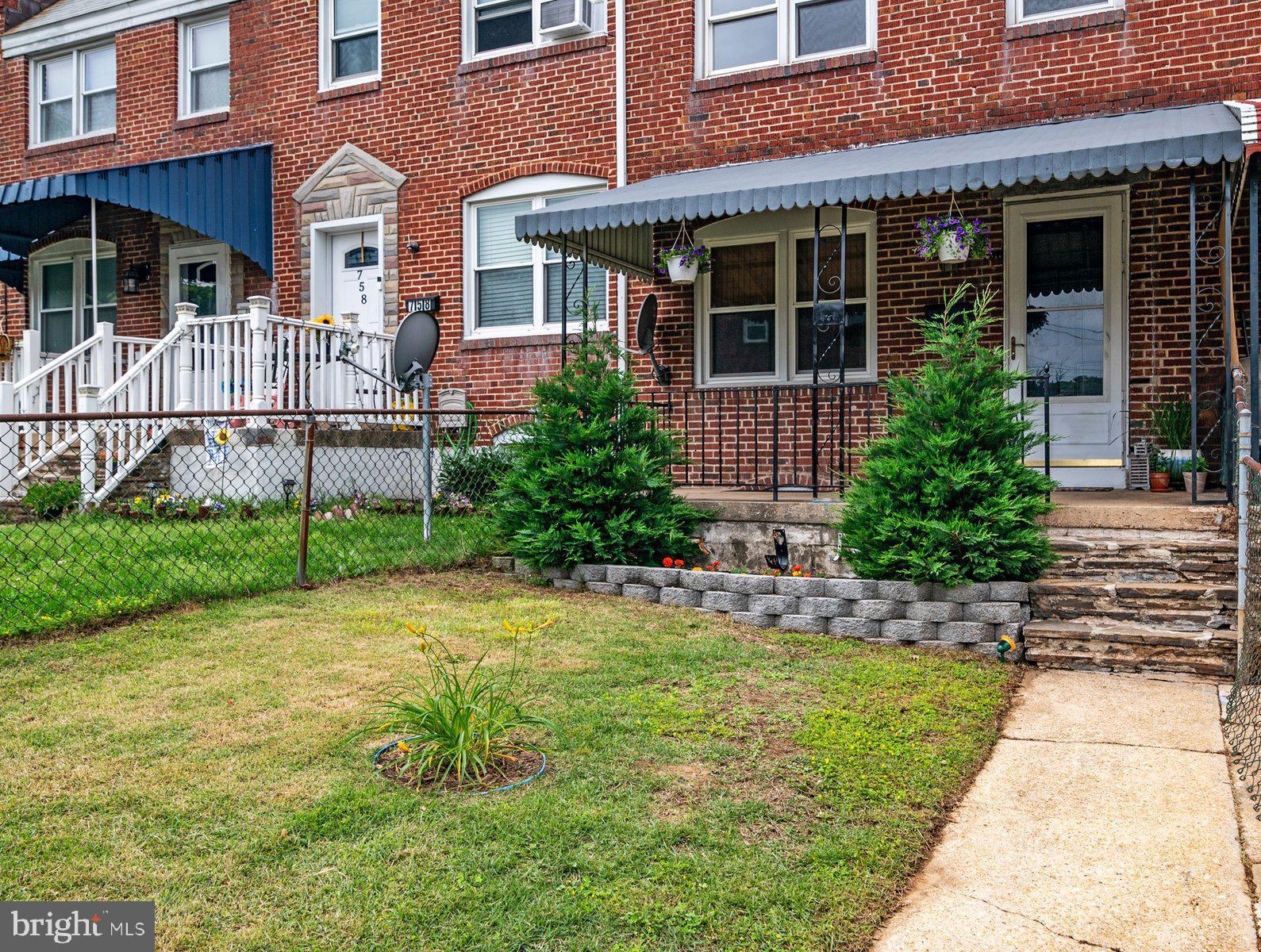 a view of a house with potted plants and a yard