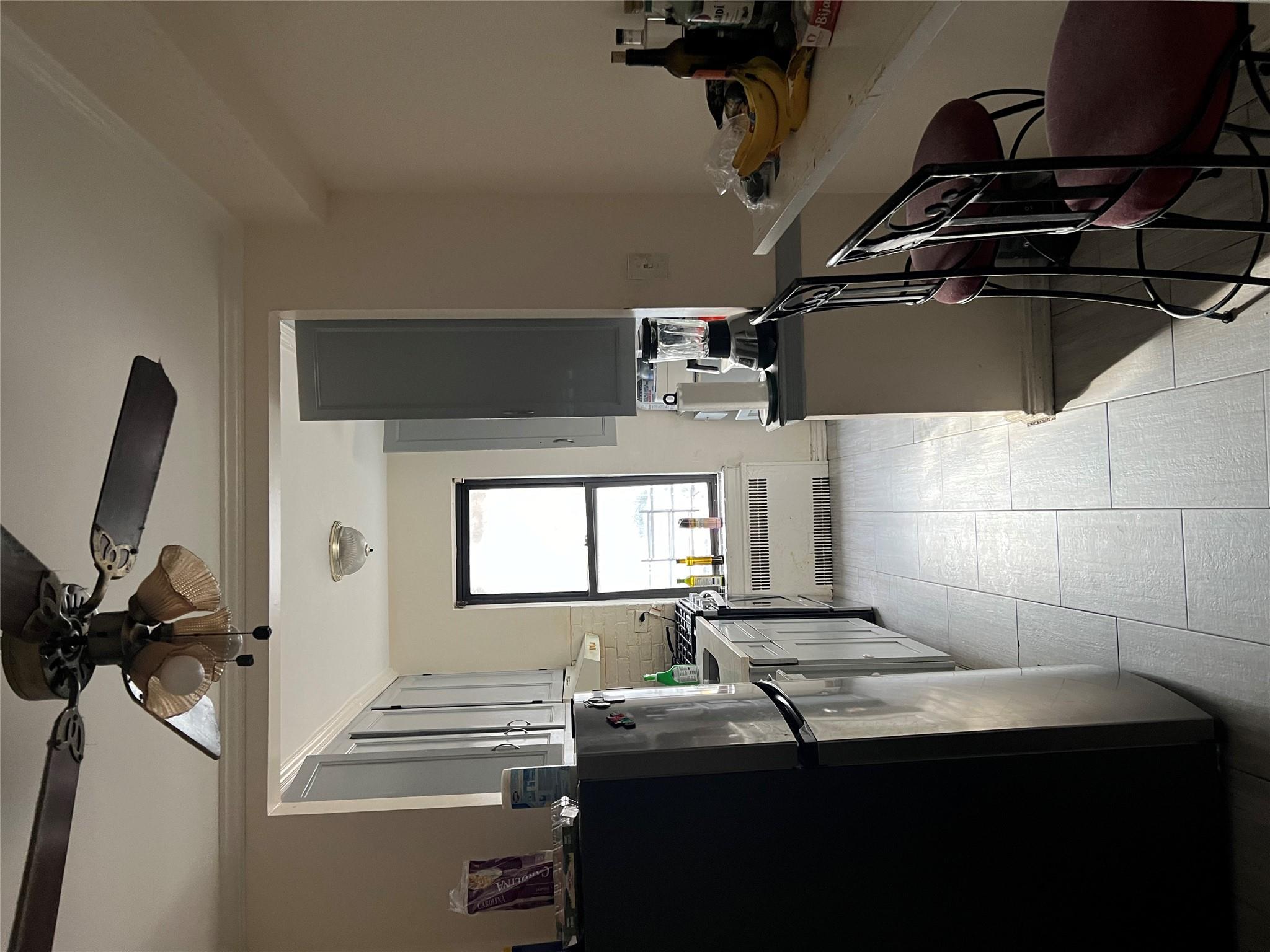 a kitchen with a table chairs refrigerator and window