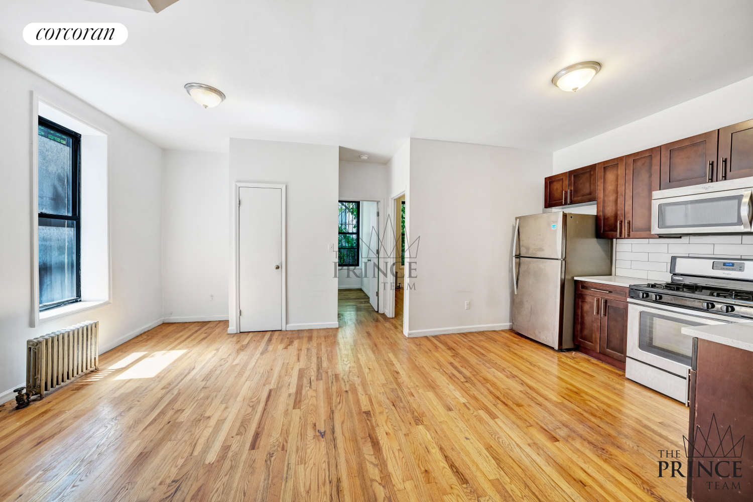 a view of a kitchen with wooden floor and electronic appliances