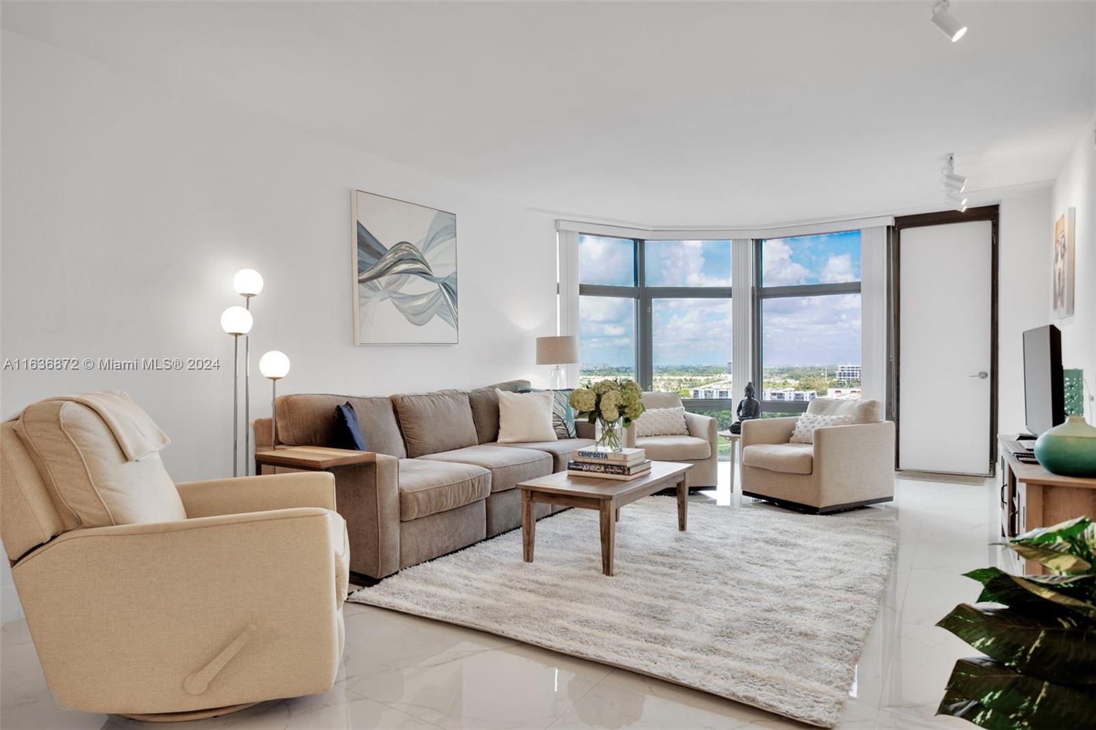 a living room with furniture and floor to ceiling windows