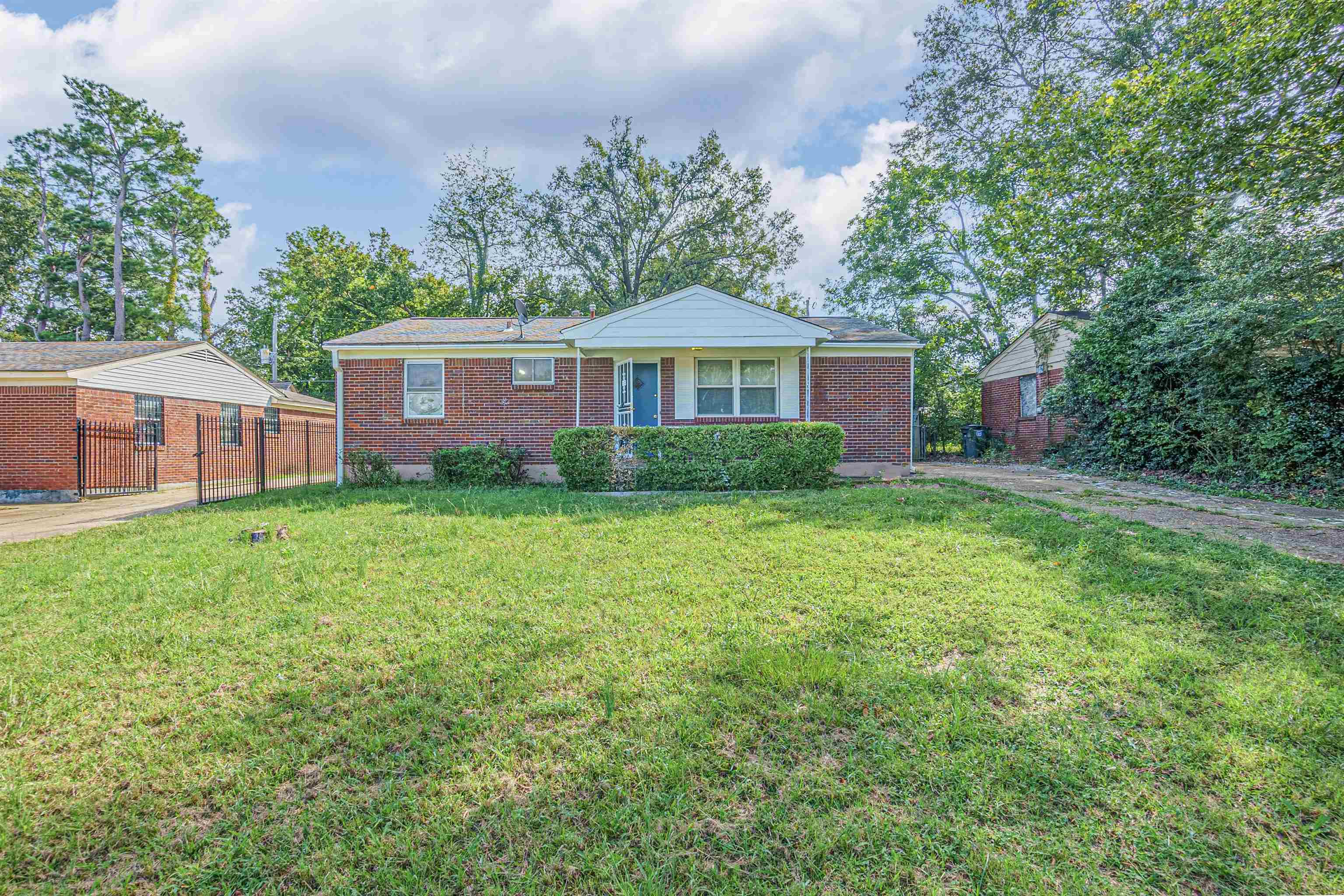 a front view of a house with yard and green space