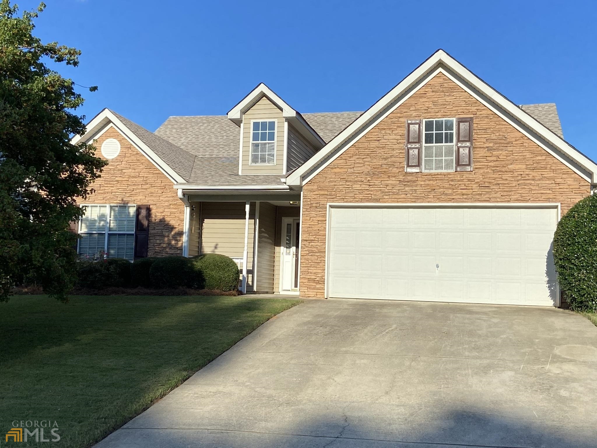 a front view of a house with a yard and garage