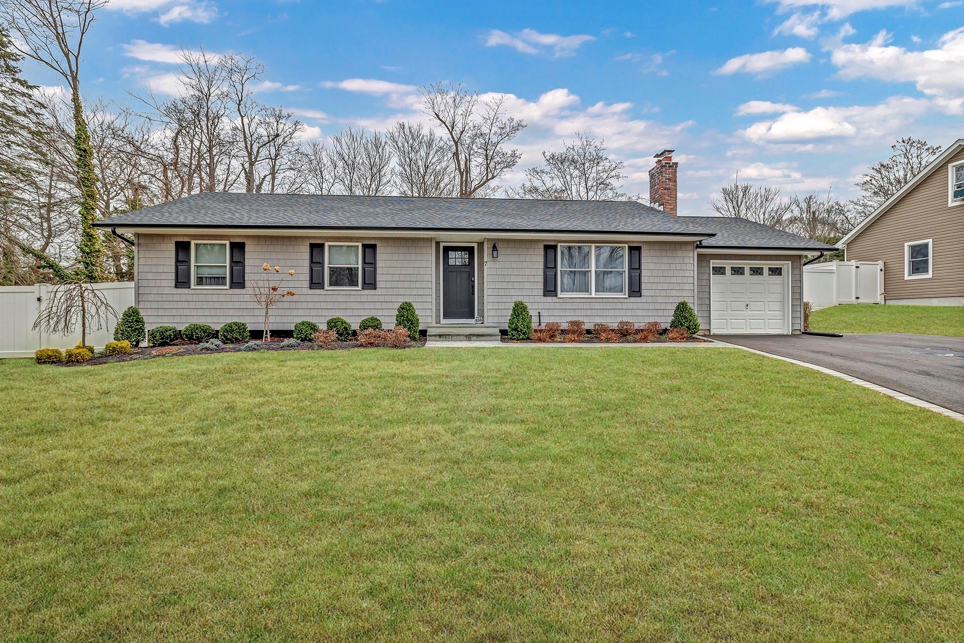 Ranch-style house with a front lawn and a garage