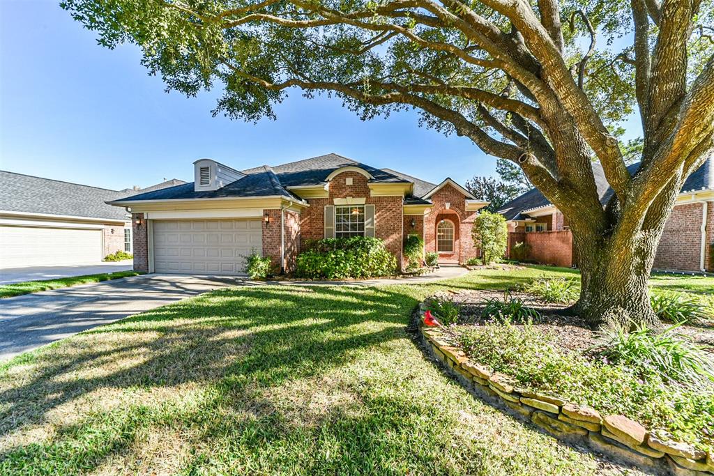 a view of a house with a big yard and large tree