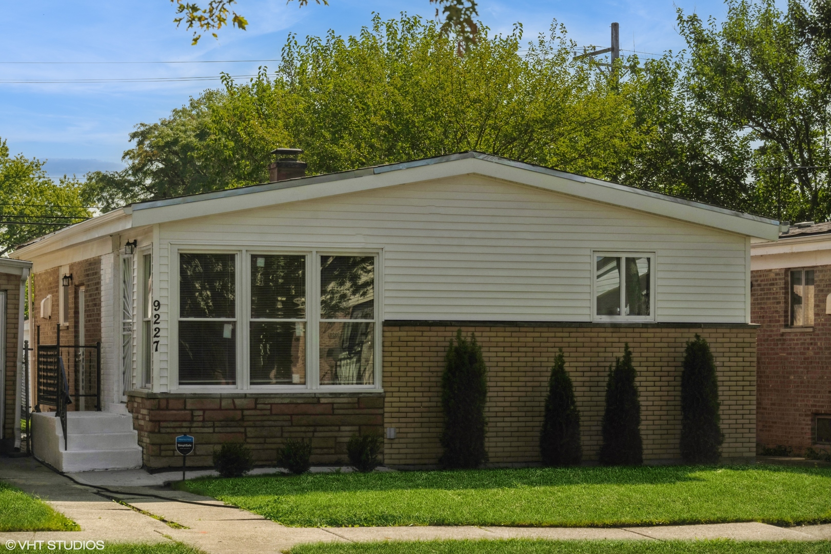 a front view of a house with a garden