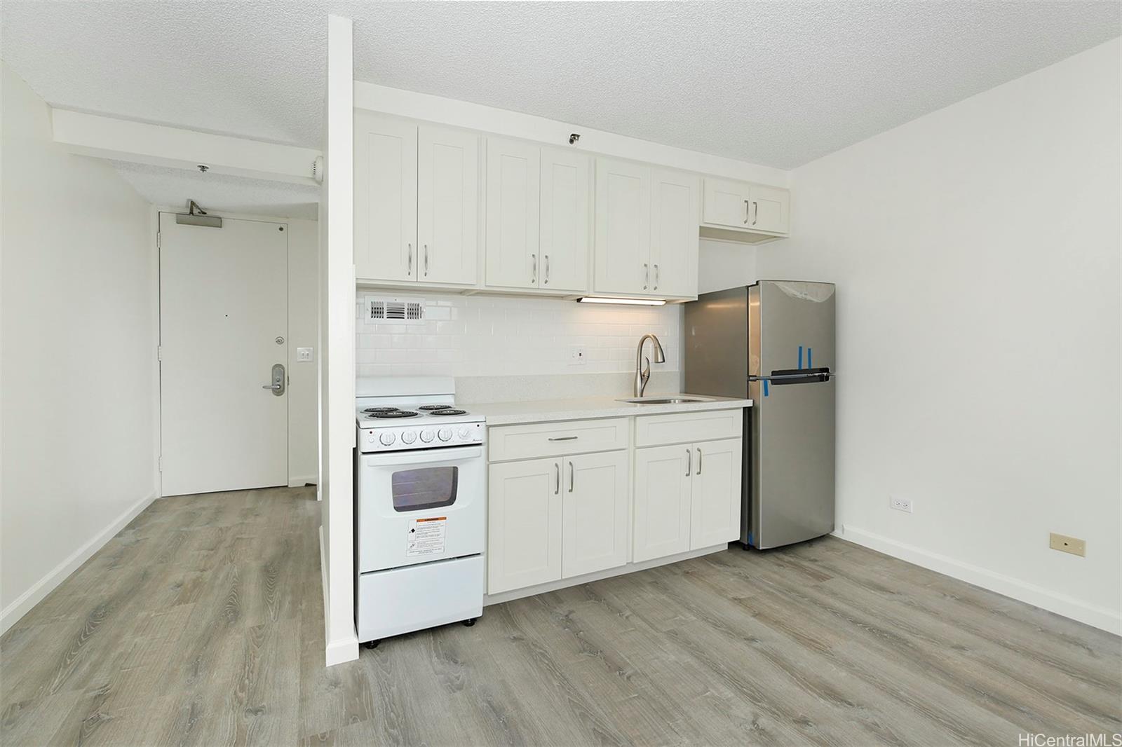 a kitchen with a stove cabinets and wooden floor