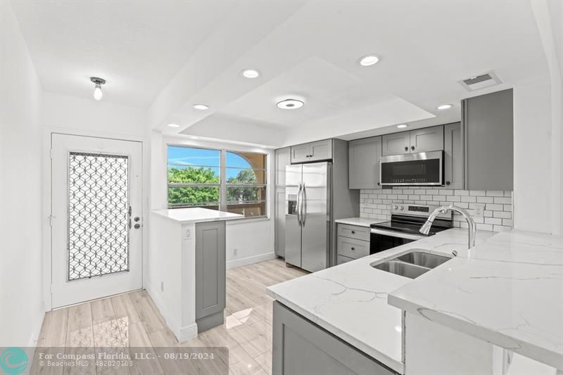 a kitchen that has a sink a stove and a refrigerator